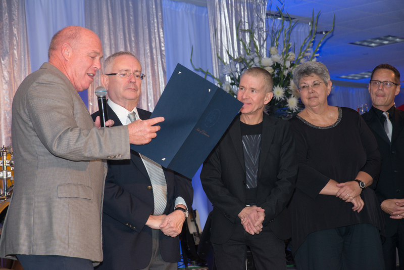 Rep. Pete Schwartzkopf, left, reads a tribute to (l-r) Steve Elkins, Murray Archibald, Nathalie Moss and Chris Beagle from the Delaware House of Representatives to CAMP Rehoboth for its service and dedication to the LGBT community. BY DENY HOWETH